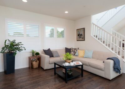 Sunlit living room with beige sectional and plants